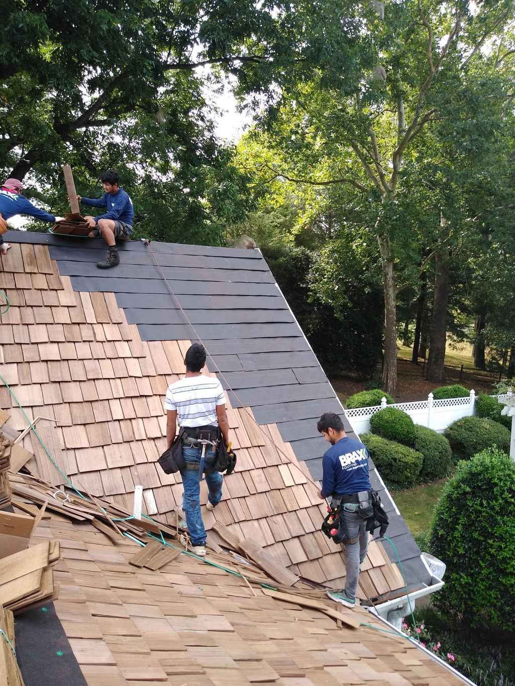 Two roofers working on a steep pitched roof